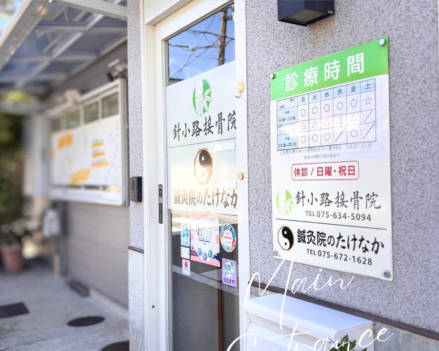 針小路接骨院の入口と診療時間の案内板